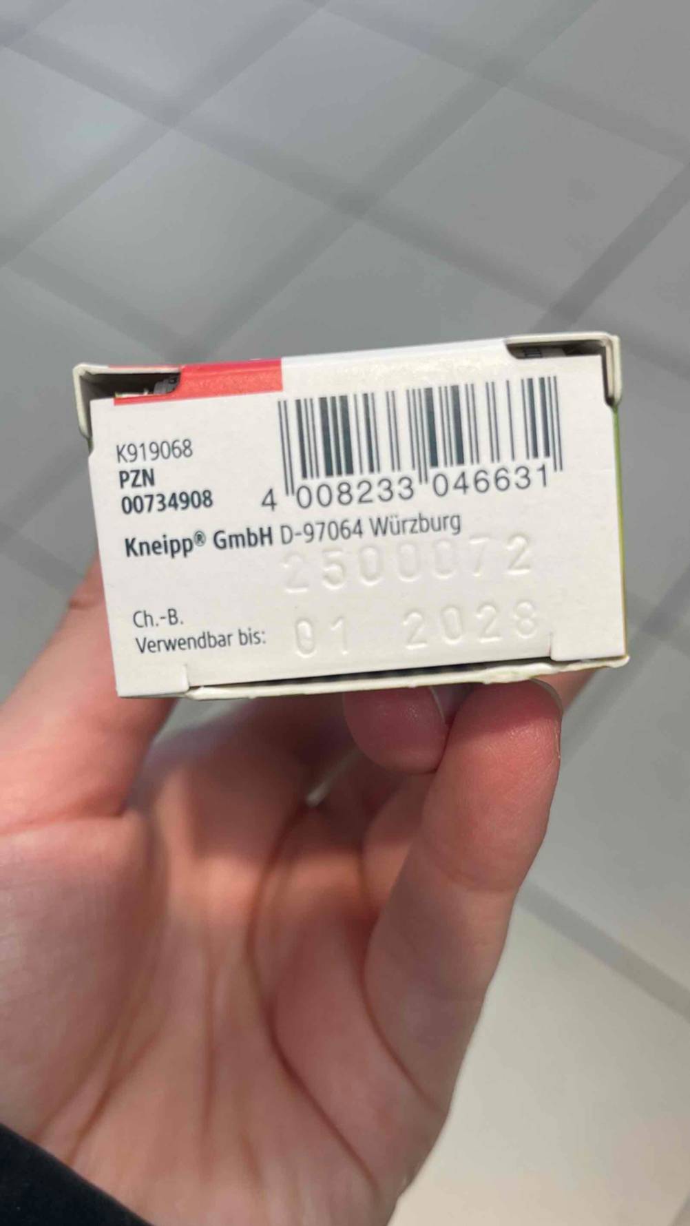 Getestet: Das Arnika-Gel in der Verpackung befindet sich in einer Hand, der Fokus liegt auf dem eingestanzten Verfallsdatum.