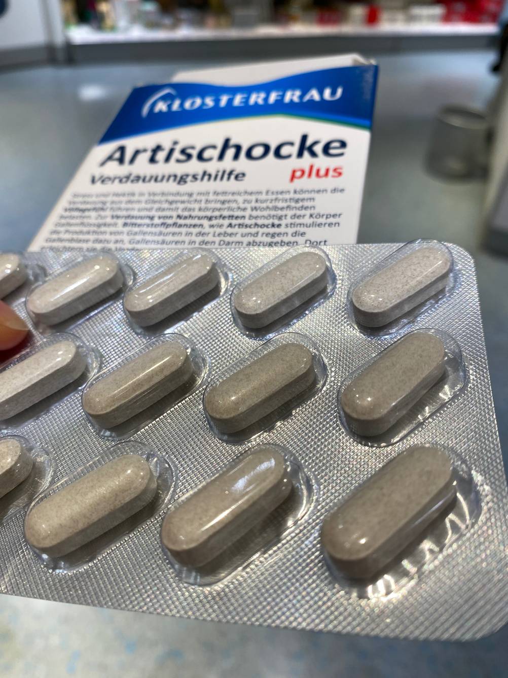 Ein Tablettenblister der getesteten Artischocken-Kapseln liegt auf der Verpackung.