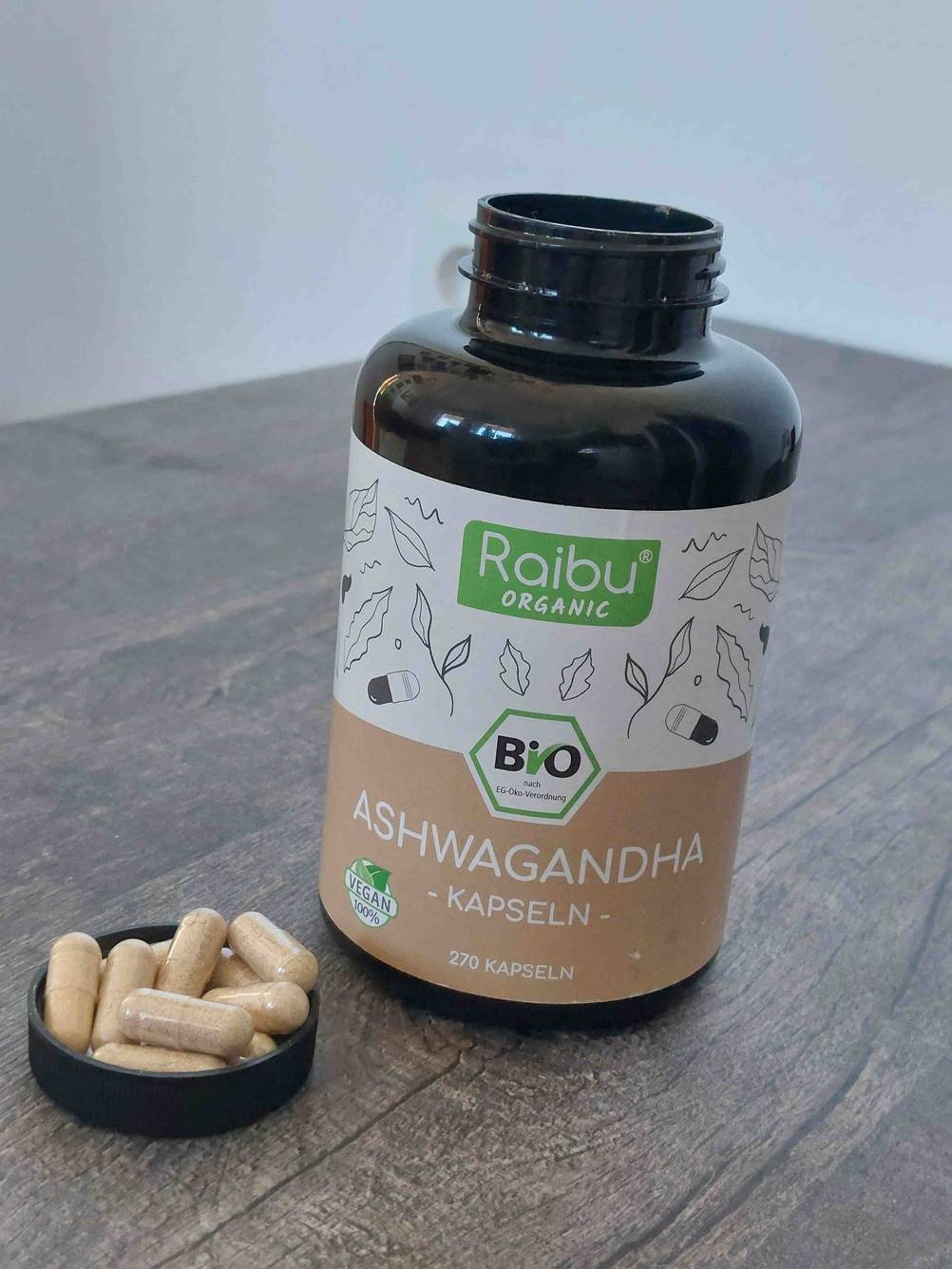 Eine Dose des getesteten Ashwagandha, daneben in der Verschlusskappe liegen einige Kapseln.