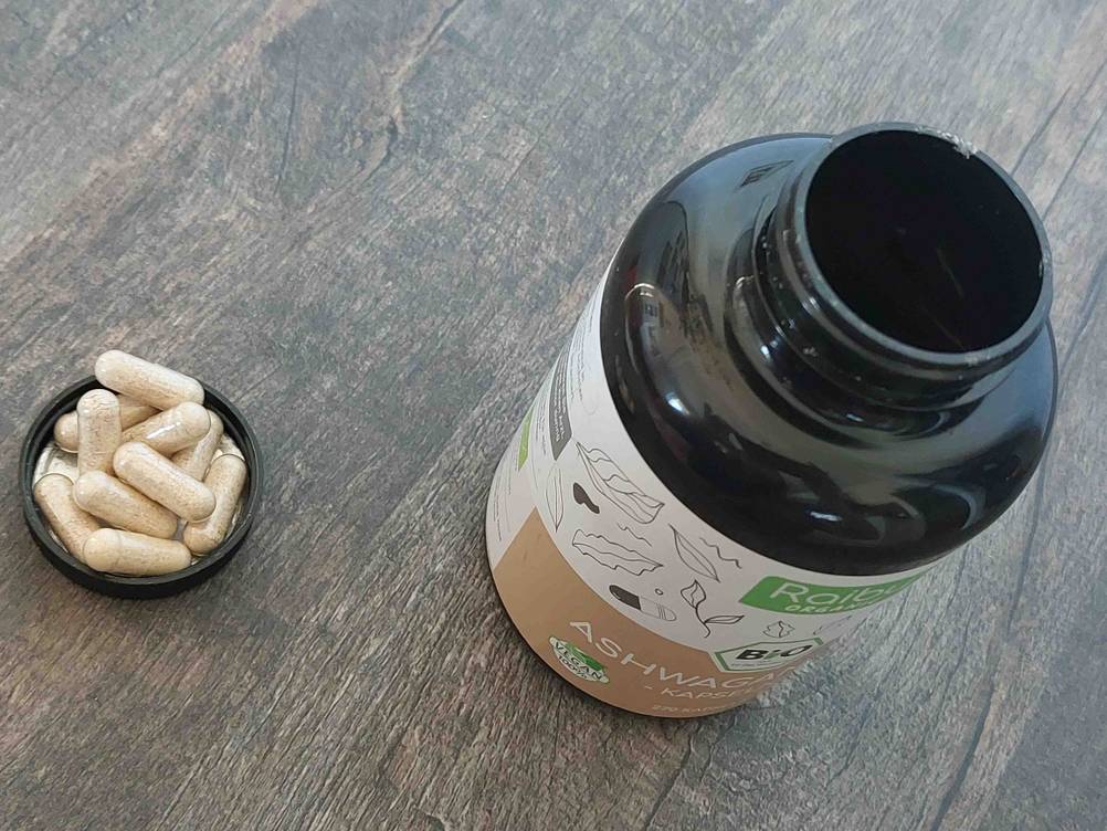 Ashwagandha getestet: Eine Dose von schärg oben, daneben liegen im Deckel einige Kapseln.