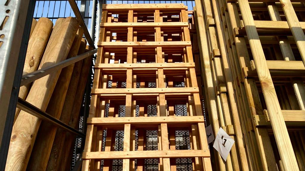 Im Test: Mehrere Rankgitter aus Holz stehen hintereinander neben anderen Holzmaterialien in einem großen Verkaufsregal.