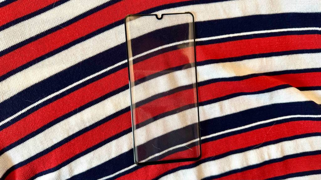 Im Test: Eine Huawei P30 Pro-Schutzfolie liegt auf einem bunt-gestreiften Tuch.