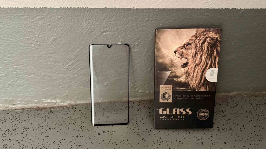 Eine getestete Huawei P30 Pro-Schutzfolie steht neben der Verpackung auf einem Boden.