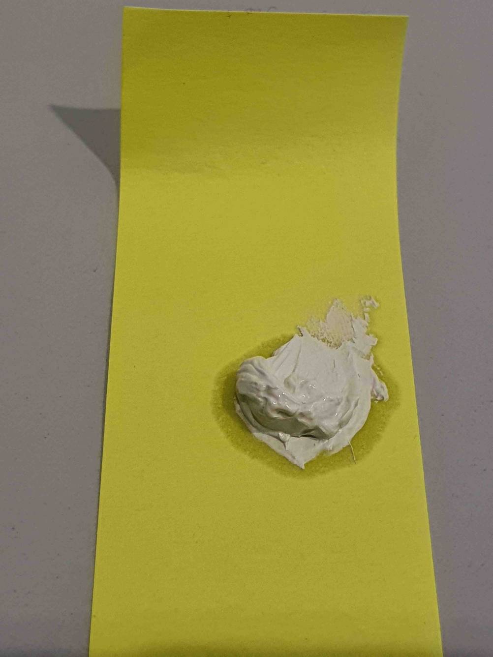 Auf einem gelben Streifen ist ein Klecks getestete Wärmeleitpaste.