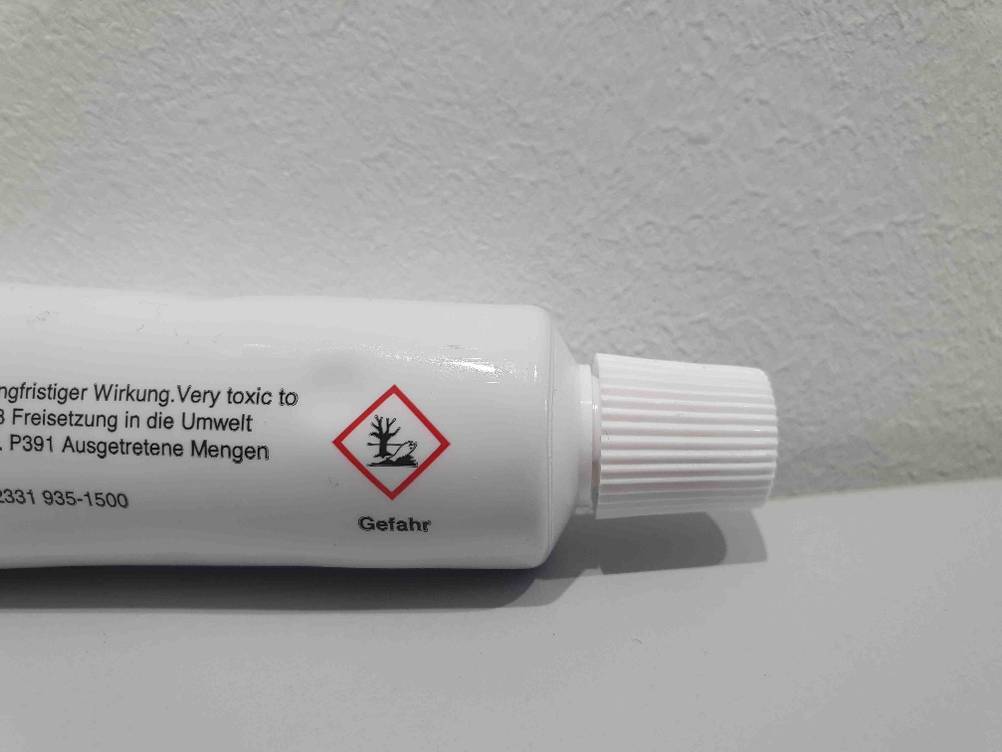 Auf der Tube von getesteter Wärmeleitpaste sind Warnhinweise aufgedruckt.