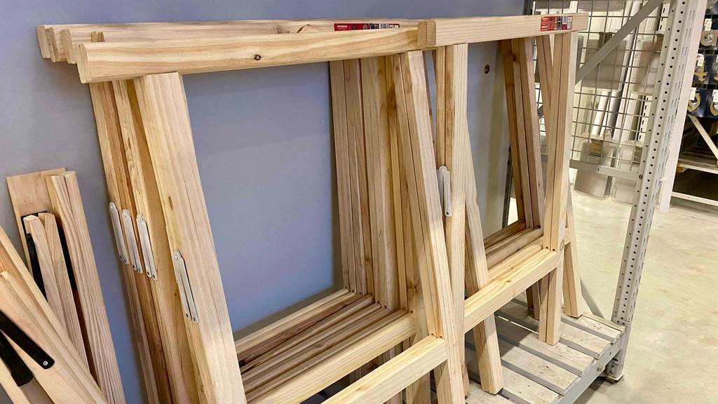 Mehrere Holz-Klappböcke im Test befinden sich flach geschlossen im Verkaufsbereich in einem Baumarkt.