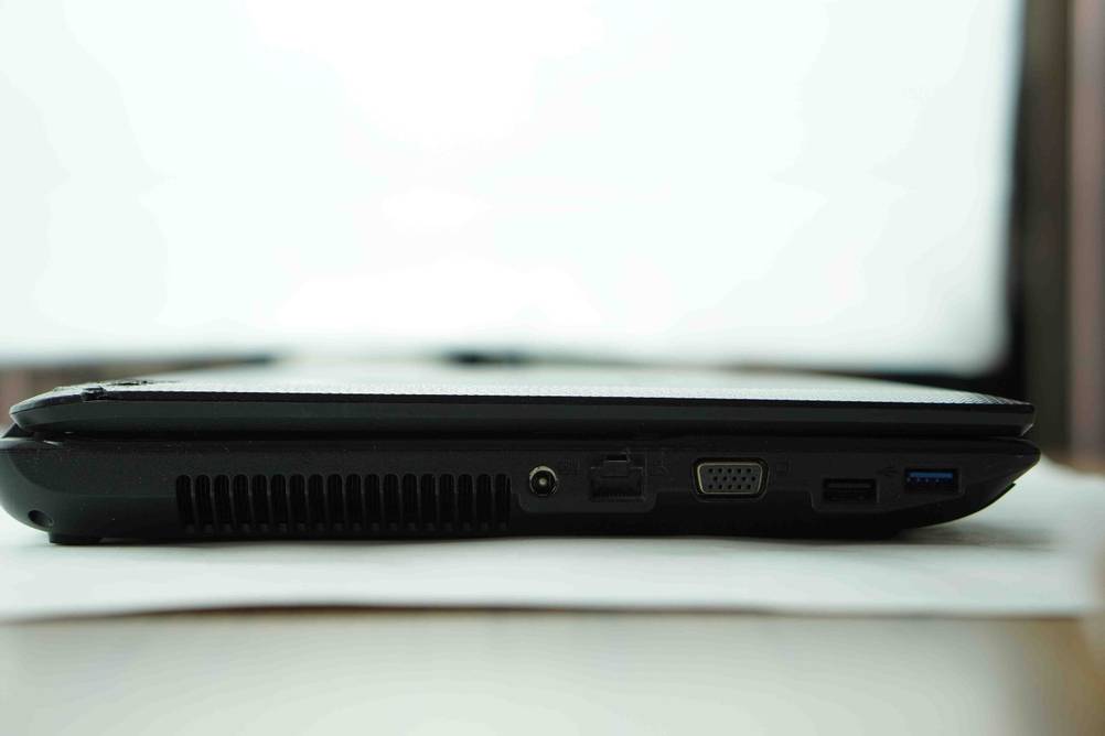 Seitenansicht mit Anschlüssen eines Asus-Laptops auf einer hellen Fläche.