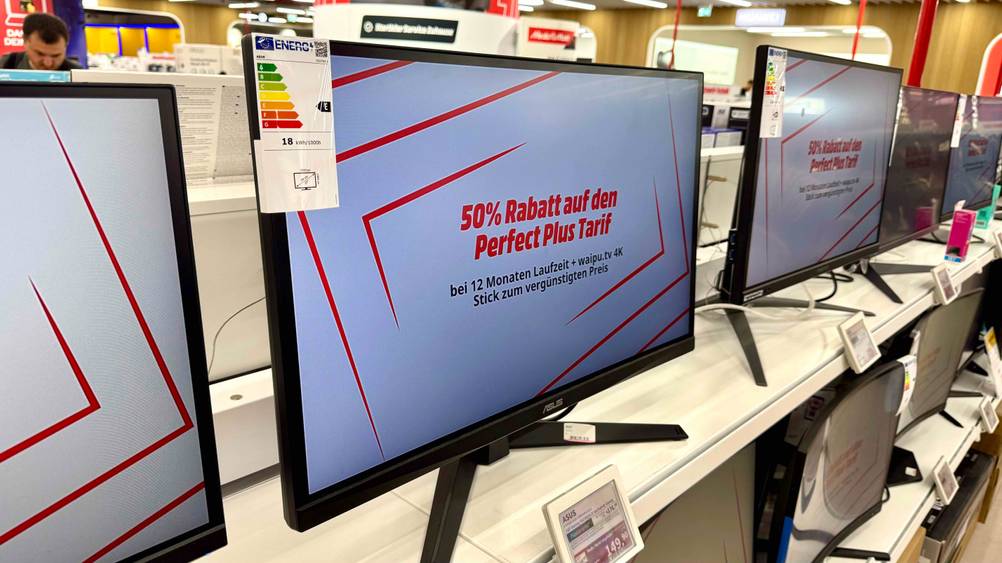 Auf einem Verkaufsregal zwischen anderen Produkten steht der getestete Asus-Monitor (27 Zoll) mit Preisangabe.