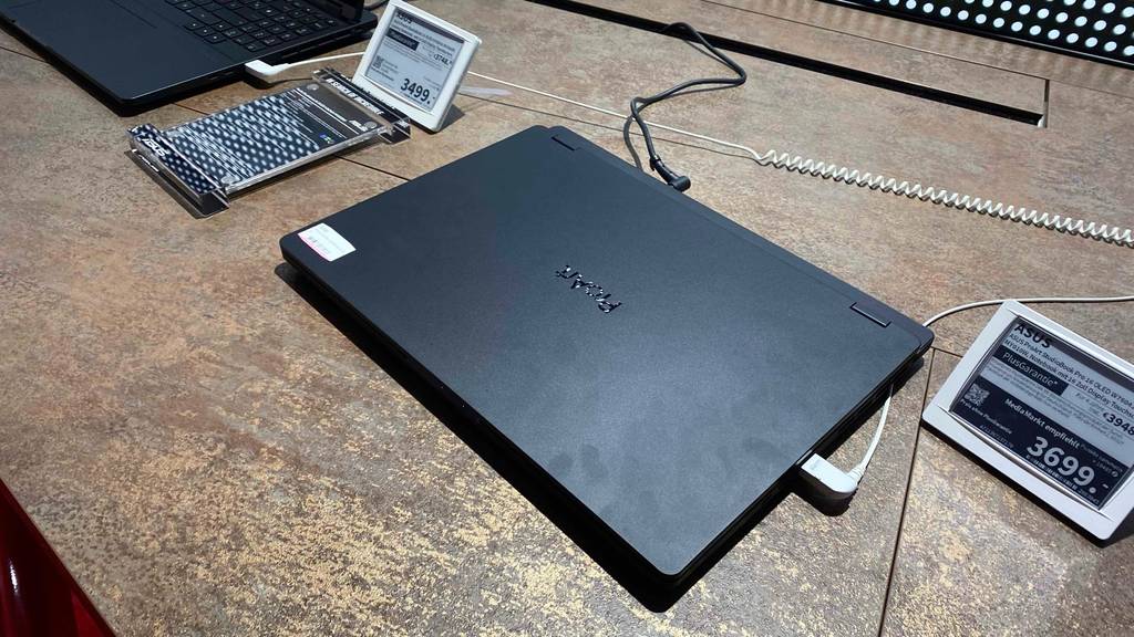 Asus Notebook mit Touchscreen im Test steht geschlossen neben seinem Preisschild auf einem Ausstellungstisch in einem Geschäft.