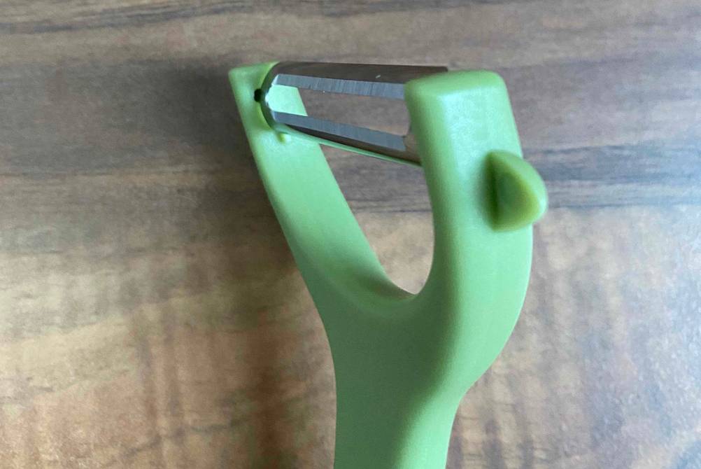 Pendelschäler im Test: Detailansicht eines grünen Modells mit Fokus auf die Klinge.