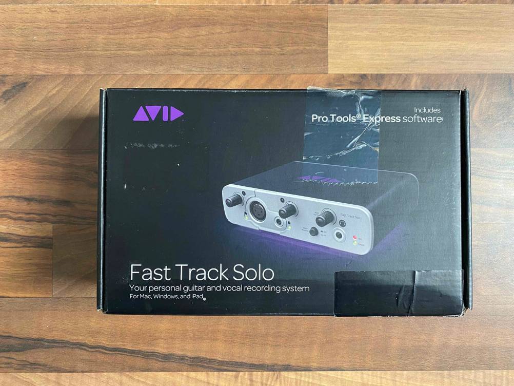 Vorderseite einer Originalverpackung eines getesteten Audio-Interface auf einer Holzfläche.