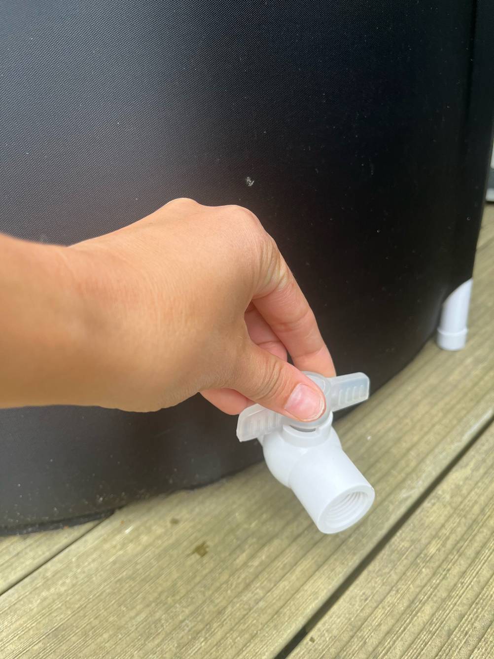 Aufblasbare Badewanne getestet: Hand greift nach Abfluss.