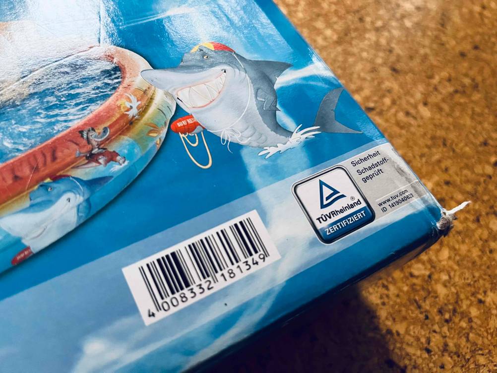 Nahaufnahme der Grafkik 'TÜV zertifiziert' auf der Verpackung eines aufblasbaren Pools.