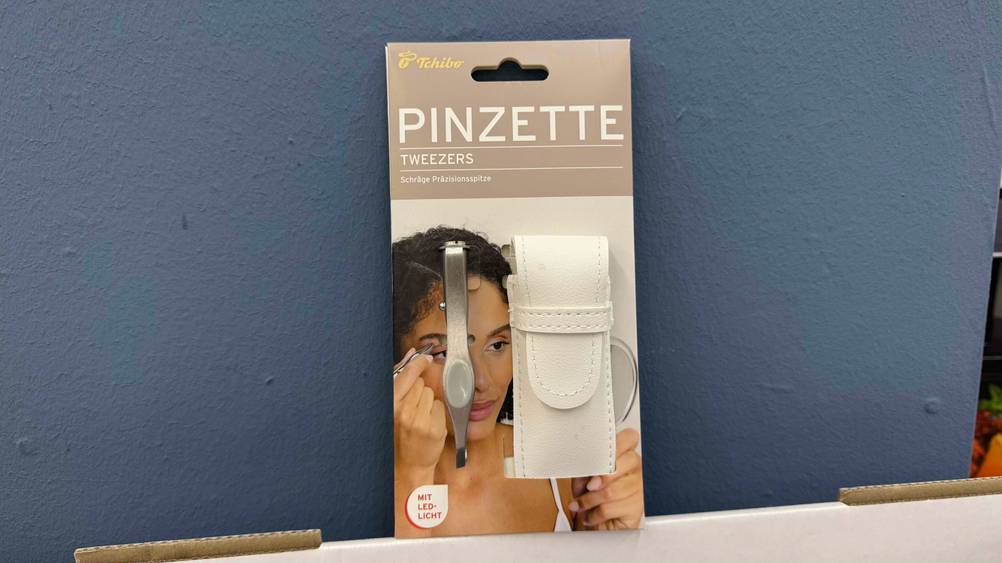 Vor einer blauen Wand lehnt die Augenbrauenpinzette im Test.