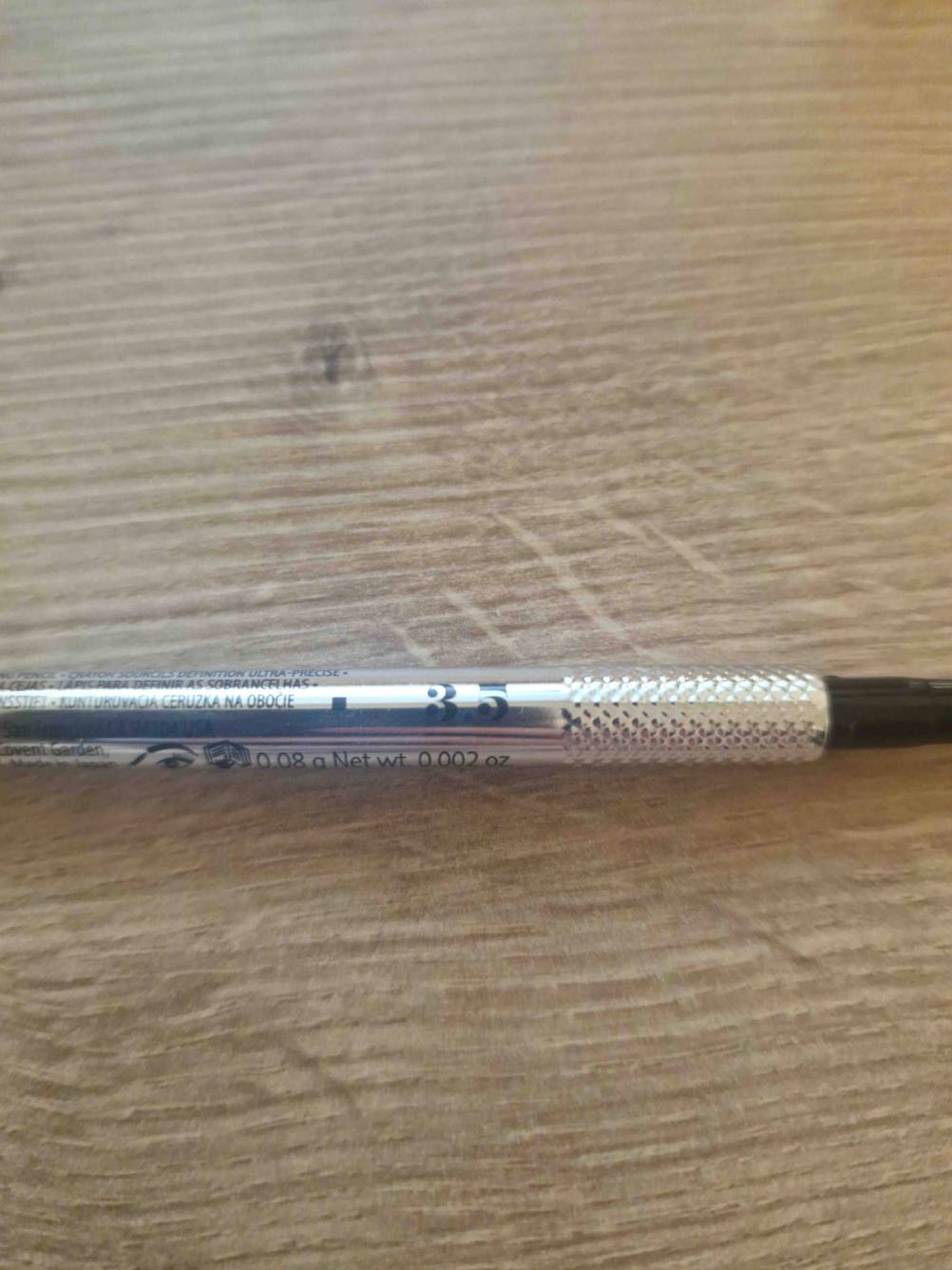 Nahaufnahme des Aufdrucks auf einem getesteten Augenbrauenstifts auf einem Holztisch.