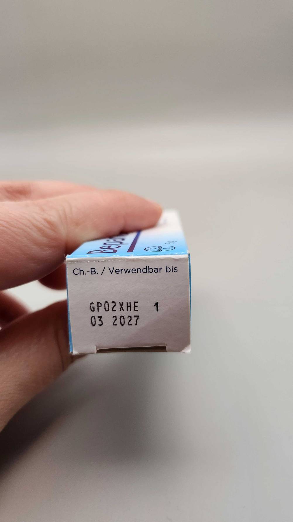Augensalbe-Test: Eine Hand hält die Kopfseite der Verpackung mit Angaben zur Haltbarkeit.