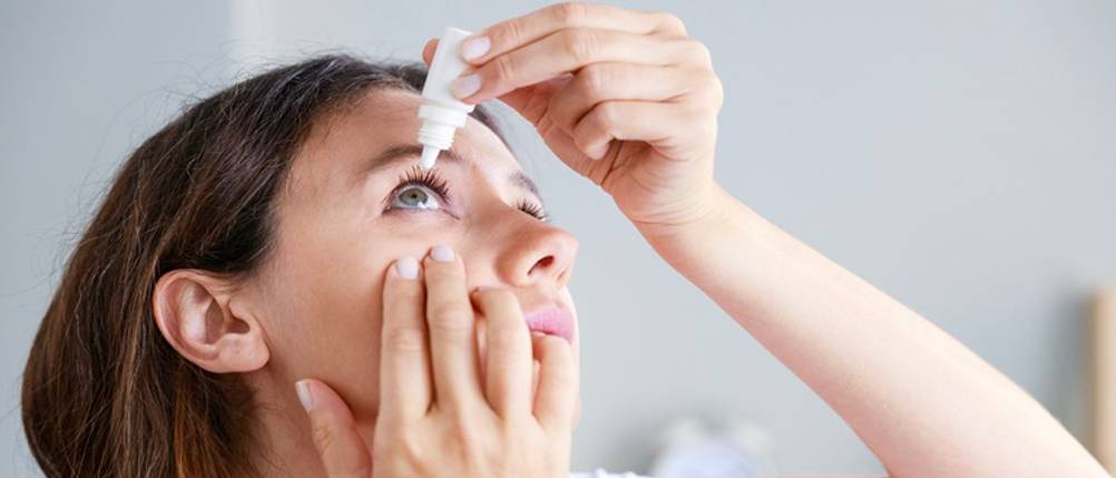 Augentropfhilfen im Test: Eine Frau tropft ihr Auge ein.