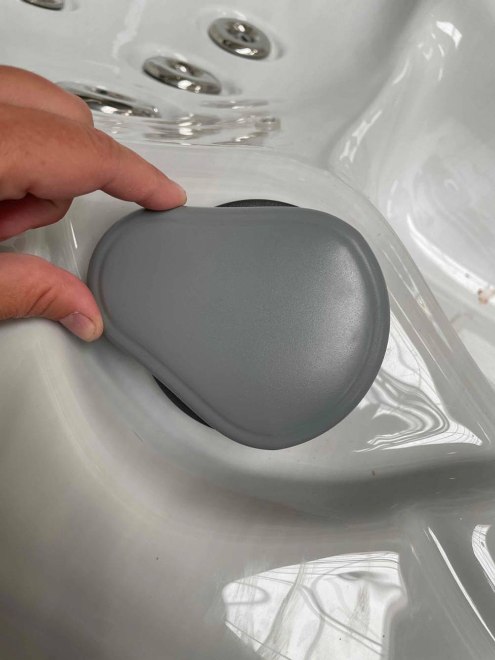 Eine Hand hält eine Verschusskappe eines Außenwhirlpools im Test.