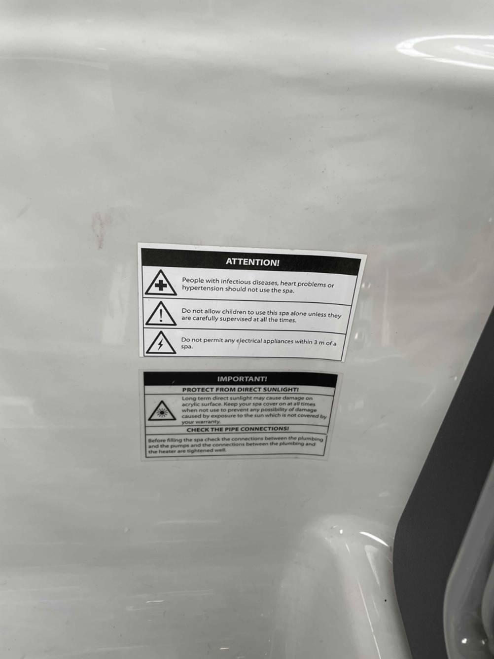 Nahaufnahme der Warnhinweise im Inneren eines getesteten Außenwhirlpools.