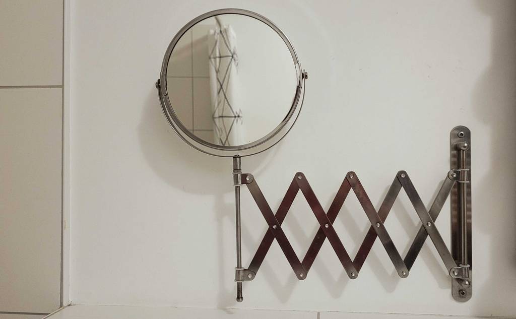 Ein getesteter Kosmetikspiegel für die Wandmontage ist ausgezogen an einer weißen Wand.