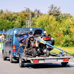 auto-anhaenger-mit-motorrad-und-spanngurten