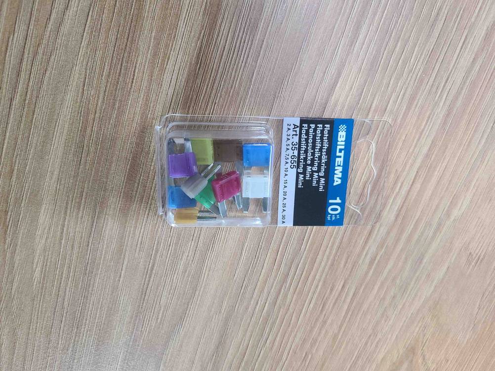 Die getesteten Auto-Sicherungen in der transparenten Verpackung auf einem Holztisch.