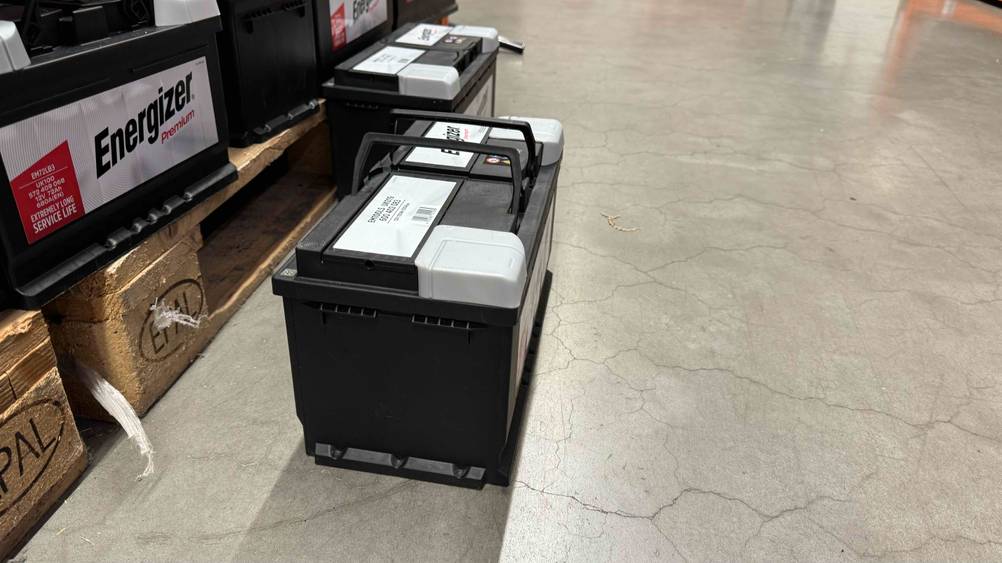 Getestet: Eine Autobatterie 100Ah von der Seite auf einem Betonboden stehend.