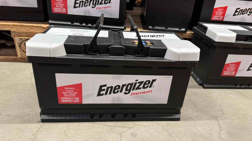 Autobatterie 100Ah im Test: Ein Gerät von vorne vor einem Regal mit mehreren anderen. Batterien.