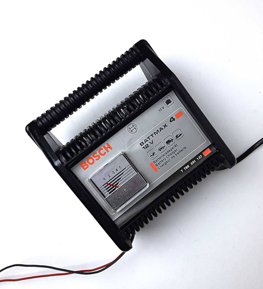 Das Autobatterie-Ladegerät im Test von vorne auf einer hellen Fläche liegend.