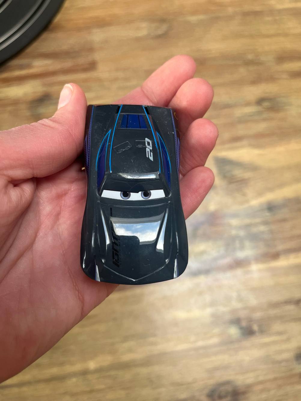 Autorennbahn-Test: Eine Hand hält ein Rennauto.