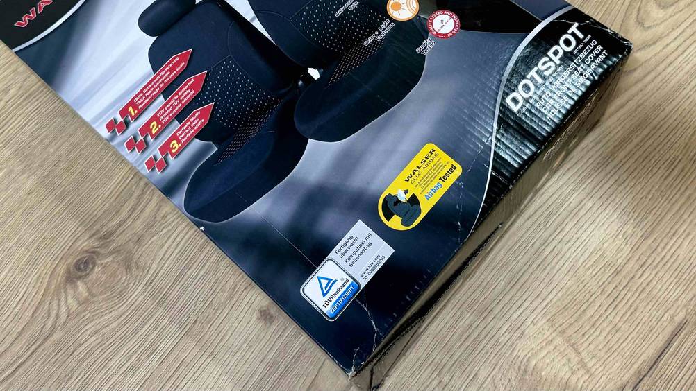 Nahaufnahme der Vorderseite der Verpackung der Autositzbezüge im Test mit Angaben zur Zertifizierung.