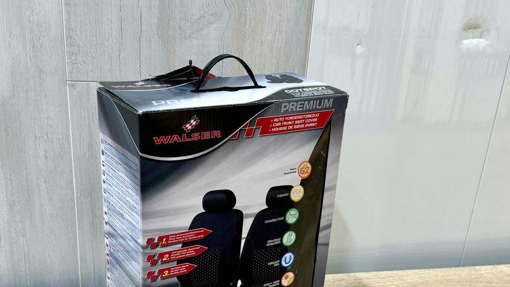 Nahaufnahme der Vorderseite der Originalverpackung der getesteten Autositzbezüge mit Logo und Inforgrafiken.