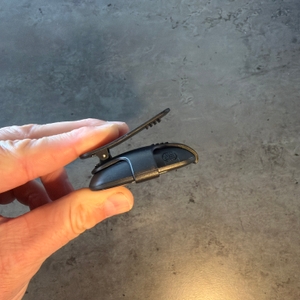 Eine Hand öffnet die Befestigung am Halter vom Avtrek-3D-Schrittzähler