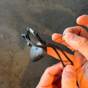 Eine Hand befestigt den Tragegurt vom Avtrek-3D-Schrittzähler