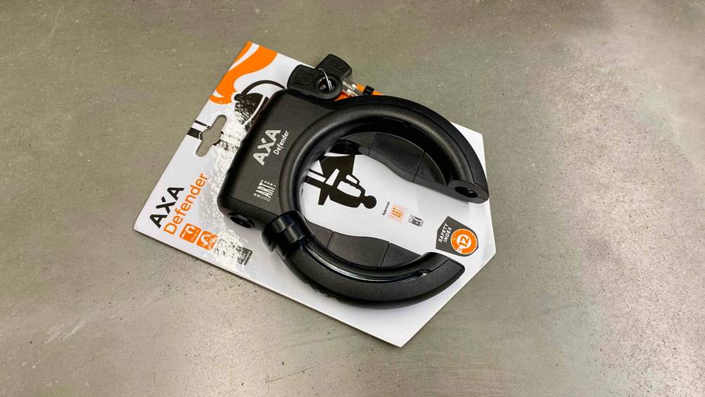 Ein getestetes Rahmenschloss originalverpackt auf einem Betonboden quer.