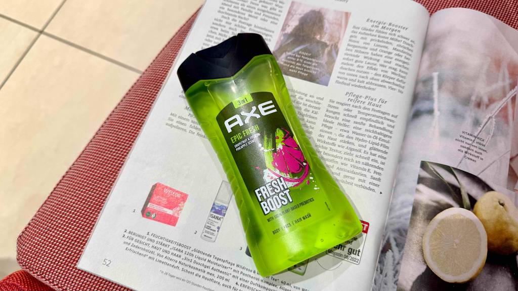Eine Flasche getestetes AXE-Duschgel liegt auf einer aufgeschlagenen Zeitschrift.