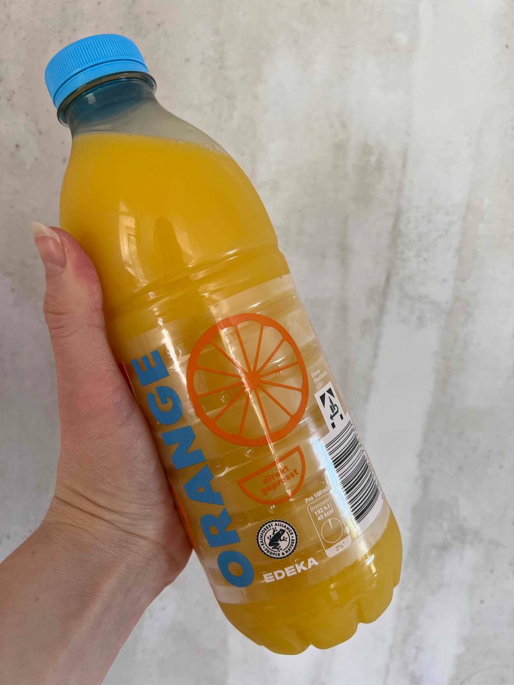 Orangensaftin der Hand.