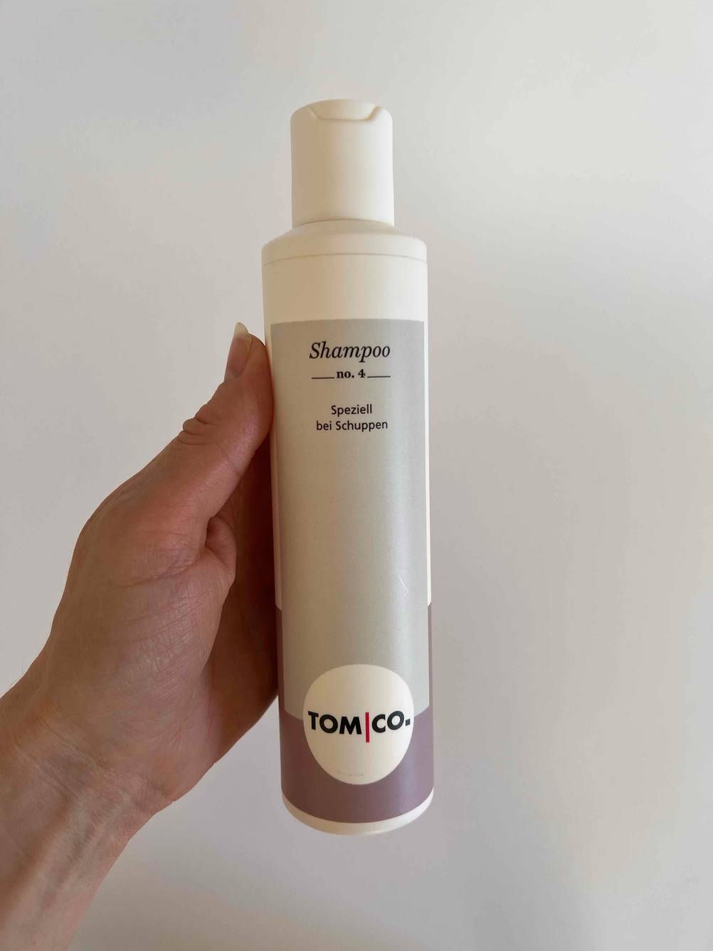 Shampoo Flasche in der Hand.
