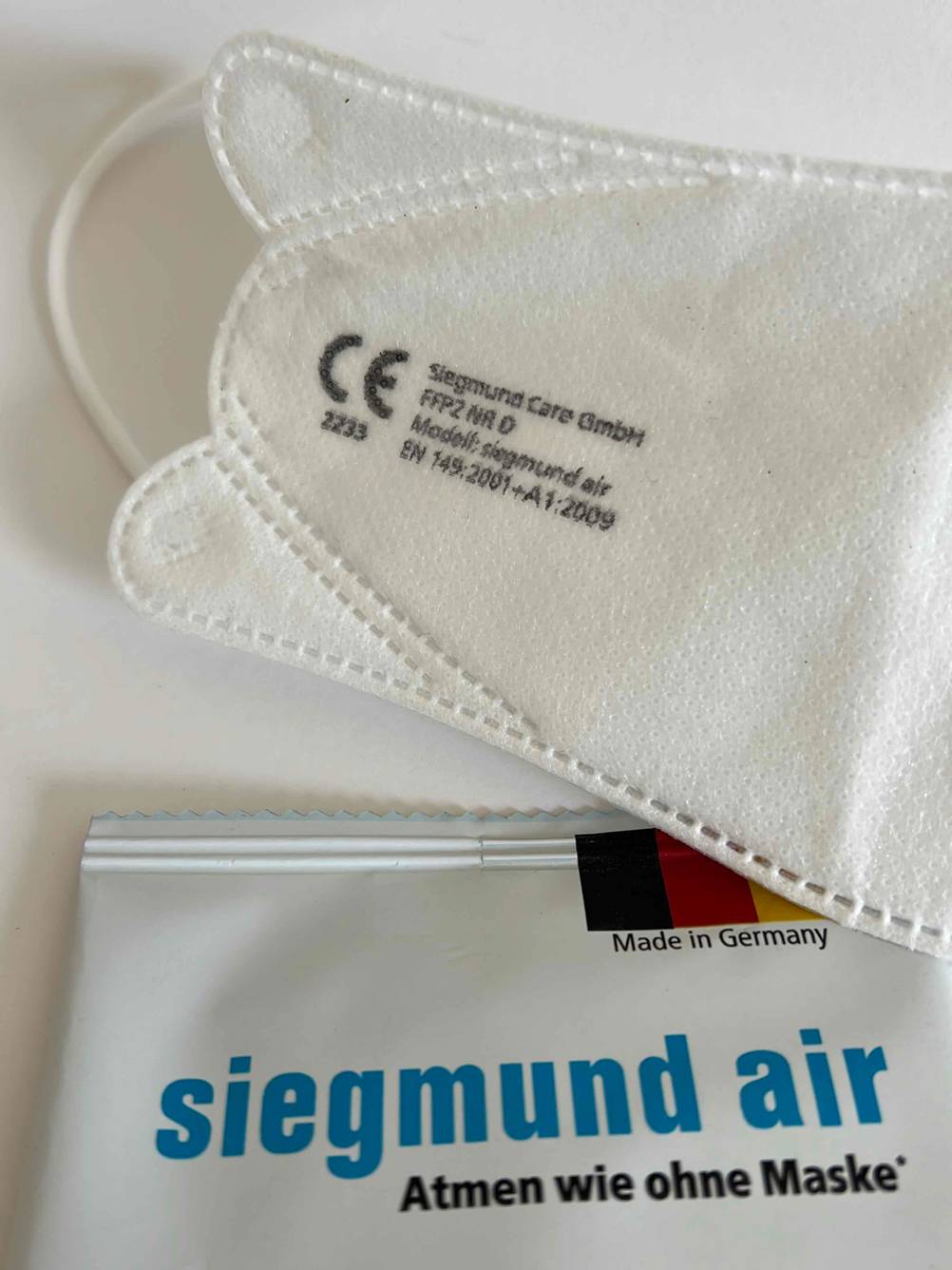 FFP2-Masken „Made in Germany“ im Test: Maske mit Verpackung auf hellem Untergrund