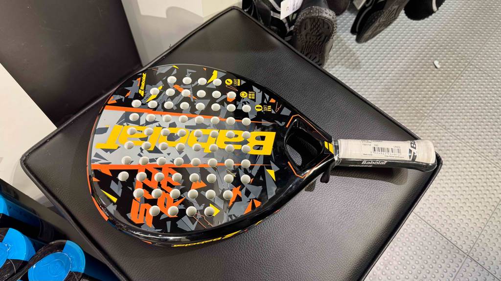 Blick von oben auf einen getesteten Padel-Schläger, der auf einem Lederhocker liegt.