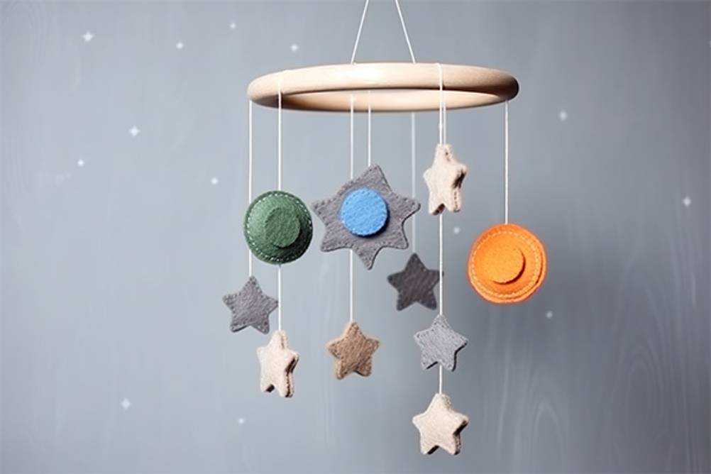Baby-Mobile im Test: ein Holzring, an dem kleine Sterne und Planeten aus Filz angebracht sind.