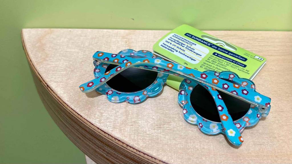 Eine zusammengelegte Baby-Sonnenbrille im Test liegt auf einer hellen Oberfläche.