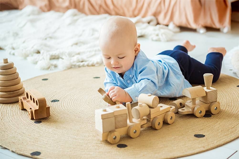 Baby-Spielzeug im Test: Ein Baby das mit Holzspielzeug spielt.