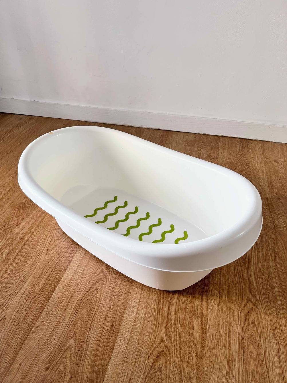 Babybadewanne getestet: Eine Wanne von schräg oben auf einem Holzboden.