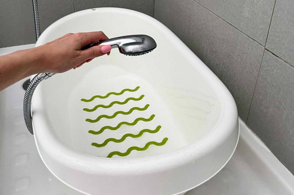 Babybadewanne im Test: Badewanne wird mithilfe von einem Duschkopf mit Wasser aufgefüllt. 