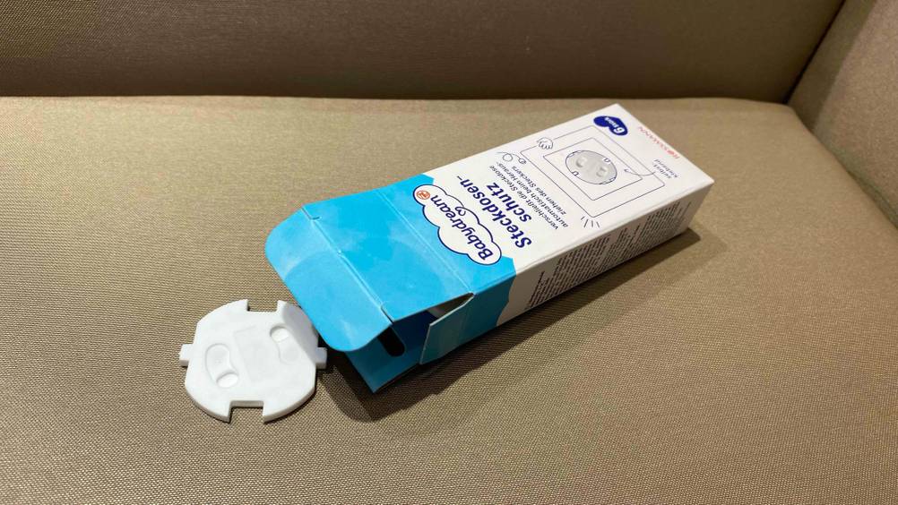 Detailansicht einer getesteten Steckdosensicherung, die vor ihrer geöffneten Originalverpackung liegt.