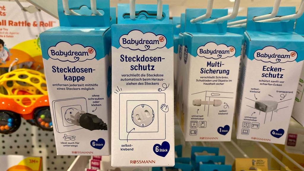 Steckdosensicherung-Test: mehrere verschiedene Ausführungen von Babydream hängen verpackt nebeneinander in einem Regal.