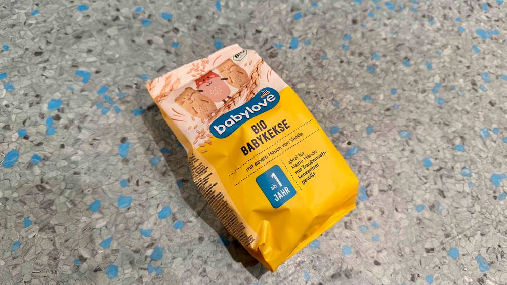 Eine Packung der getesteten Babykekse liegt auf einem grau-blauen Boden.