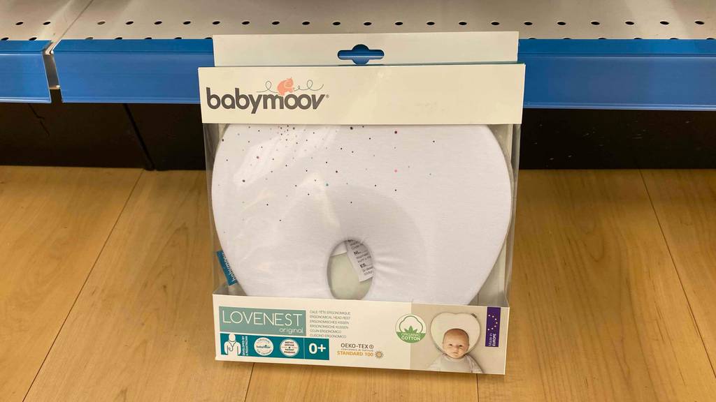 Ein getestetes Babykopfkissen liegt am Regal an. 