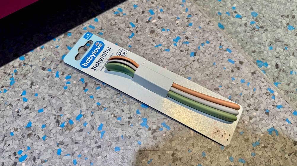 Eine Packung der getesteten Babylöffel auf einem grau-blauen Boden liegend.
